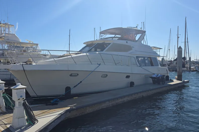2000 McKinna 48 Pilothouse yacht docked at marina under clear blue sky.