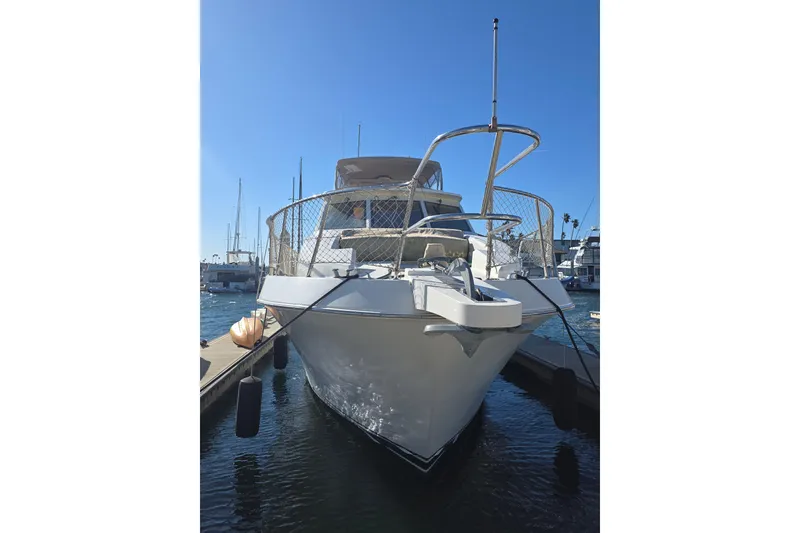 2000 McKinna 48 Pilothouse yacht docked at marina under clear blue sky.