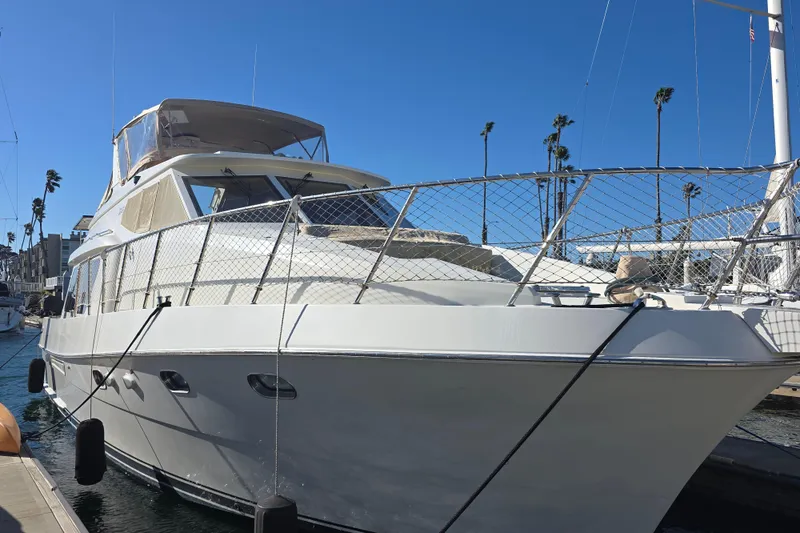 2000 McKinna 48 Pilothouse yacht docked under clear blue sky.