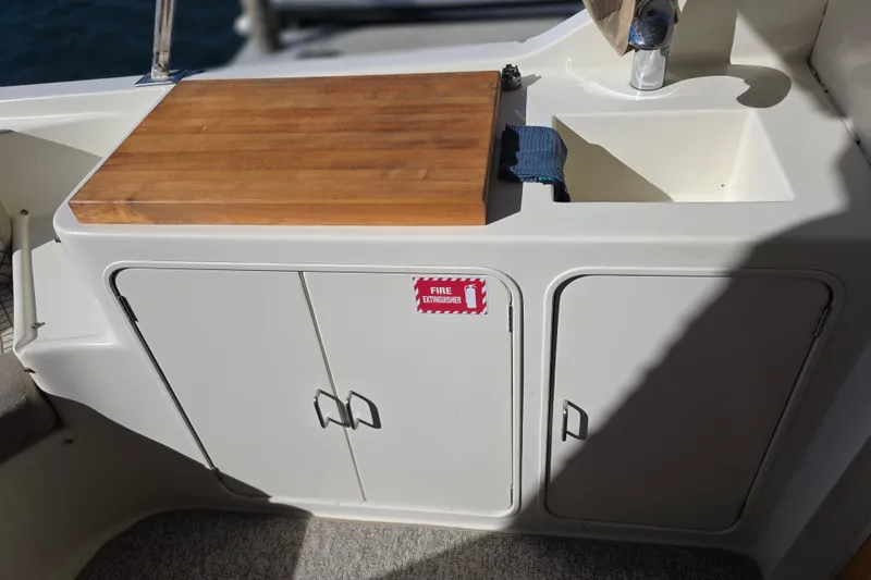 McKinna 48 Pilothouse 2000 boat kitchenette with wooden countertop and sink.