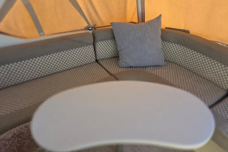 Interior seating area of 2000 McKinna 48 Pilothouse with cushioned bench and table.