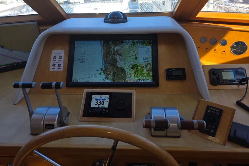 Pilothouse of 2000 McKinna 48, featuring navigation screens and control levers.