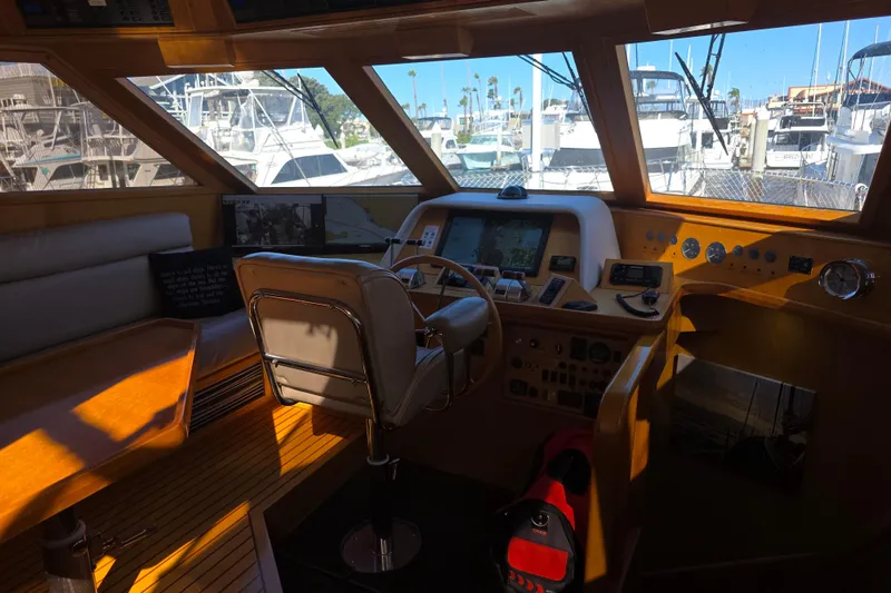 Pilothouse interior of 2000 McKinna 48, featuring navigation controls and marina view.