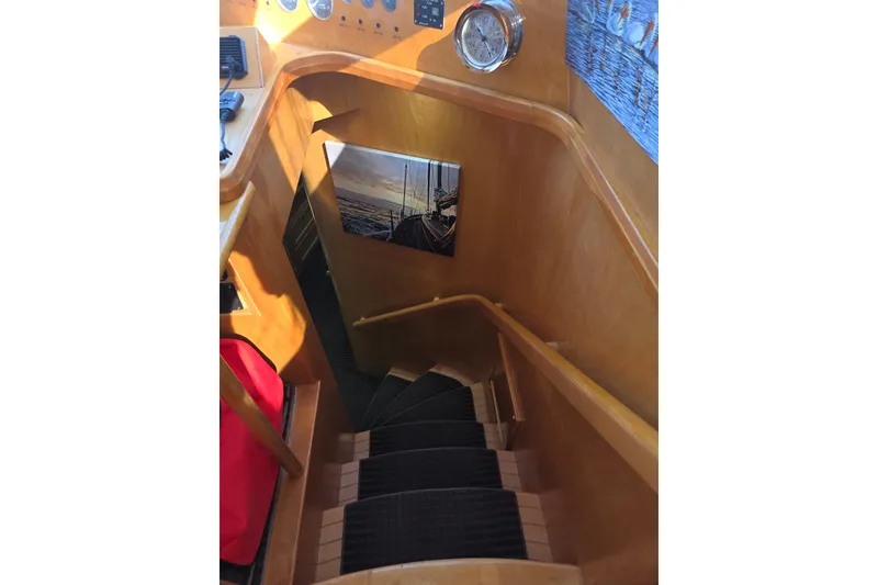 Staircase inside 2000 McKinna 48 Pilothouse yacht with wooden finish and nautical decor.