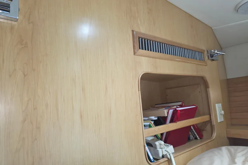 Interior of 2000 McKinna 48 Pilothouse with wooden paneling and storage shelf.