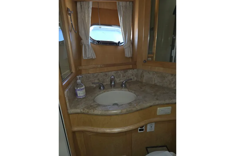 Bathroom vanity in 2000 McKinna 48 Pilothouse yacht with marble countertop and sink.