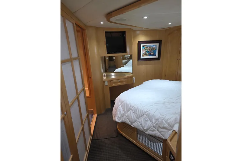 Luxurious cabin interior of 2000 McKinna 48 Pilothouse yacht with cozy bed and elegant decor.