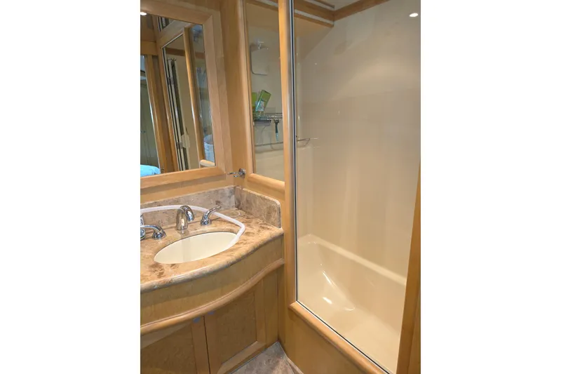 Luxurious bathroom in 2000 McKinna 48 Pilothouse yacht with marble sink and glass shower.