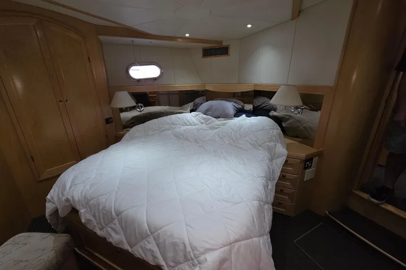 Luxurious bedroom interior of 2000 McKinna 48 Pilothouse yacht with cozy bedding.