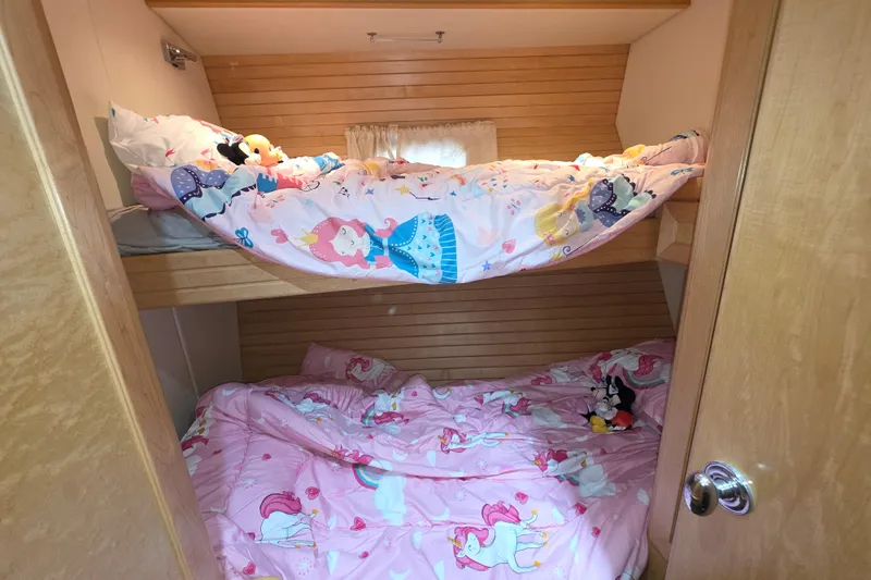 Bunk beds with colorful children's bedding in a 2000 McKinna 48 Pilothouse cabin.