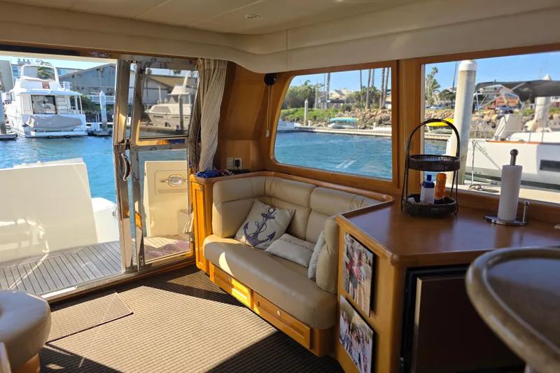 Interior of 2000 McKinna 48 Pilothouse yacht with cozy seating and marina view.