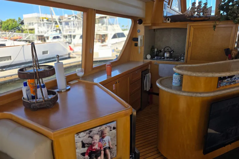 Interior of 2000 McKinna 48 Pilothouse yacht with kitchen and marina view.