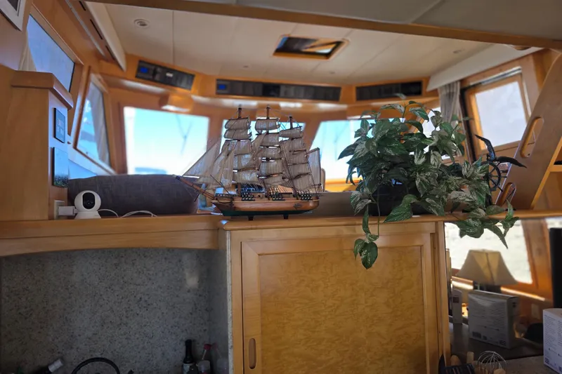 Interior of 2000 McKinna 48 Pilothouse with model ship and plant decor.