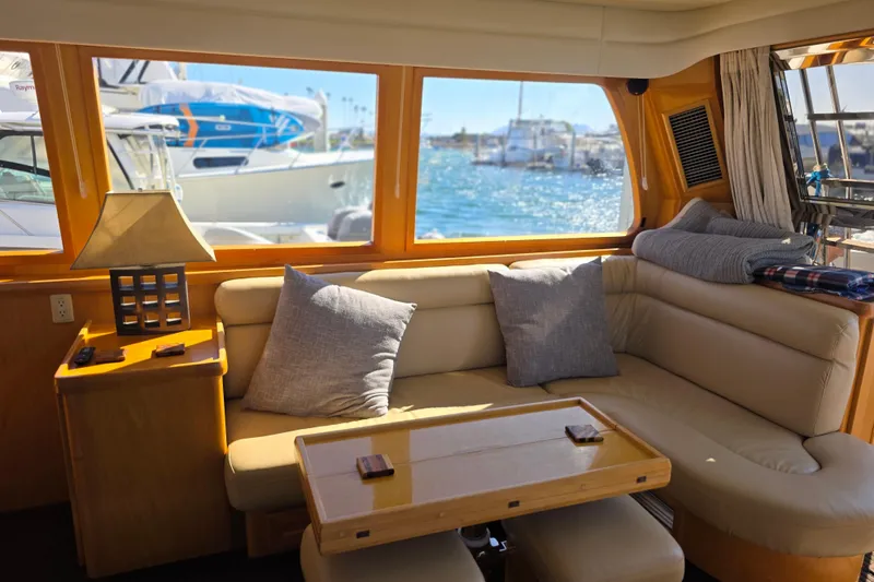 Interior of 2000 McKinna 48 Pilothouse yacht with cozy seating and ocean view.