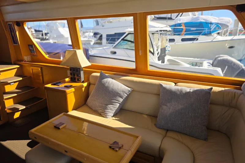 Luxurious interior of 2000 McKinna 48 Pilothouse yacht with comfortable seating and large windows.