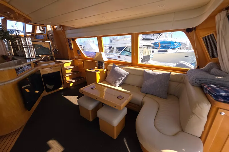 Luxurious interior of 2000 McKinna 48 Pilothouse yacht with cozy seating and elegant decor.
