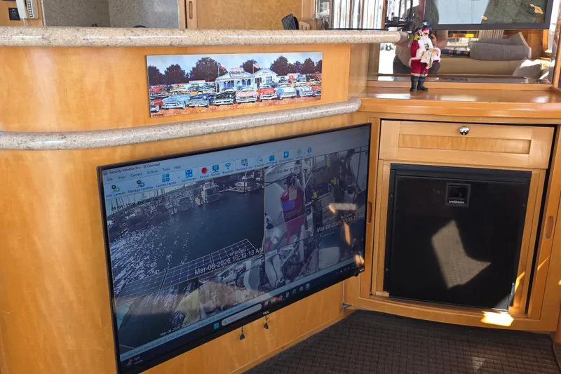 Interior of 2000 McKinna 48 Pilothouse with security monitor and wooden cabinetry.
