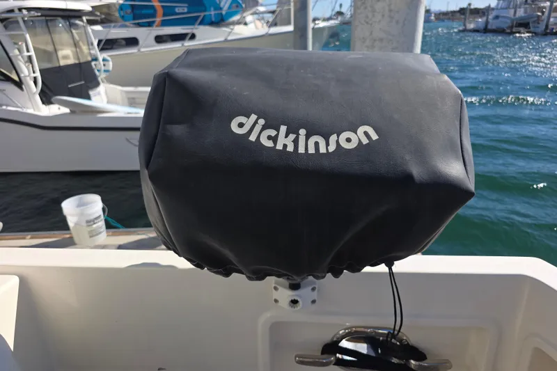Cover on a McKinna 48 Pilothouse boat, featuring Dickinson branding, docked at a marina.