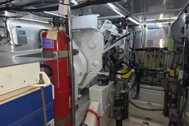 Engine room of a 2000 McKinna 48 Pilothouse yacht, featuring machinery and fire extinguisher.