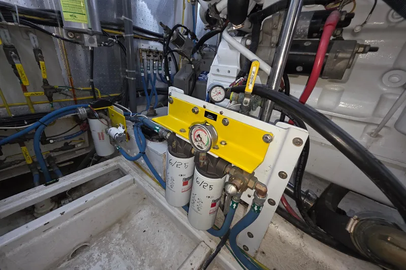 Engine room of 2000 McKinna 48 Pilothouse with fuel filtration system and gauges.