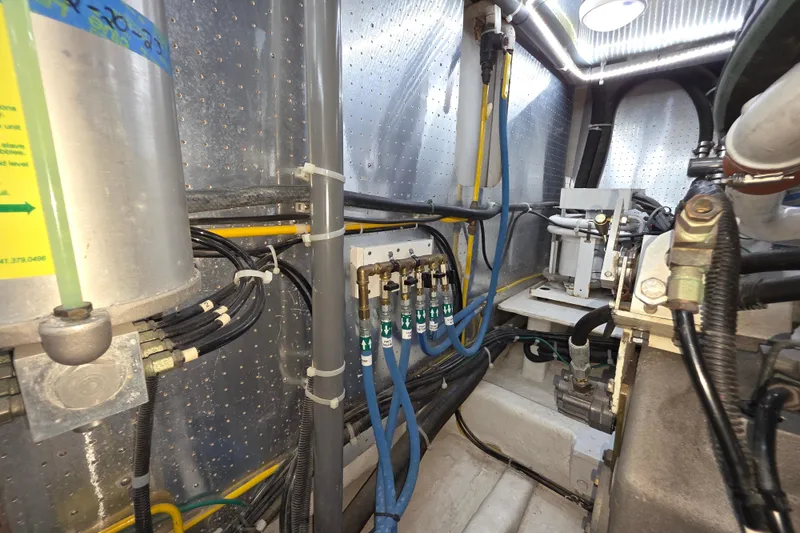 Engine room of 2000 McKinna 48 Pilothouse with visible pipes and machinery.