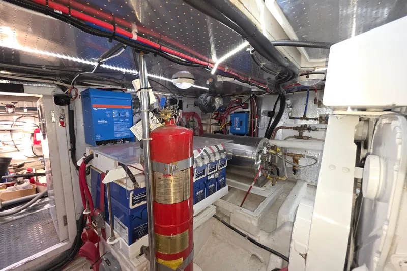 Engine room of 2000 McKinna 48 Pilothouse with fire extinguisher and electrical equipment.