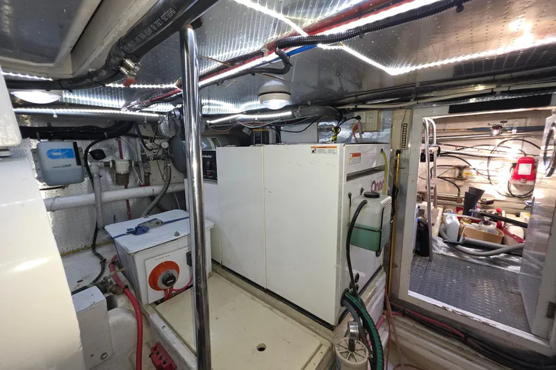 Engine room of 2000 McKinna 48 Pilothouse yacht, featuring equipment and storage.