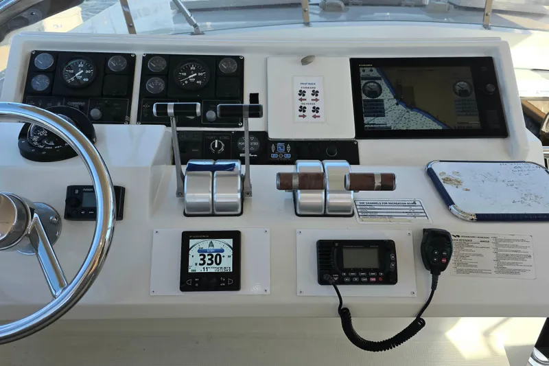 Pilothouse dashboard of 2000 McKinna 48, featuring navigation instruments and controls.