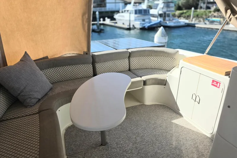 2000 McKinna 48 Pilothouse yacht interior with curved seating and table, docked at marina.