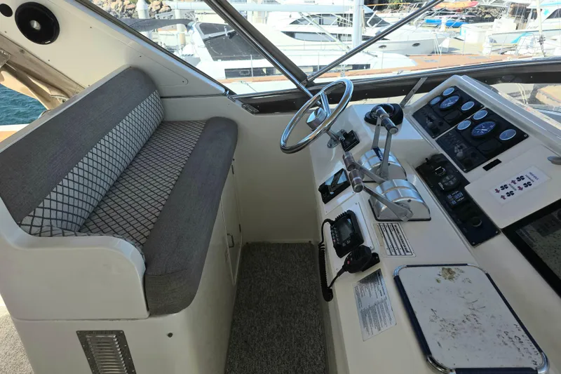 Pilothouse interior of 2000 McKinna 48, featuring steering wheel and control panel.