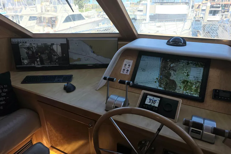 Pilothouse interior of 2000 McKinna 48, featuring navigation screens and controls.