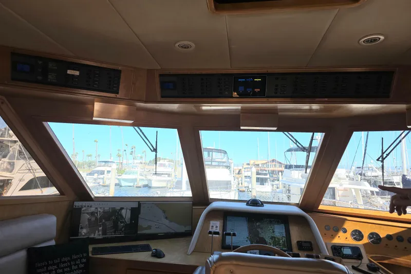 Pilothouse interior of 2000 McKinna 48, featuring navigation equipment and marina view.