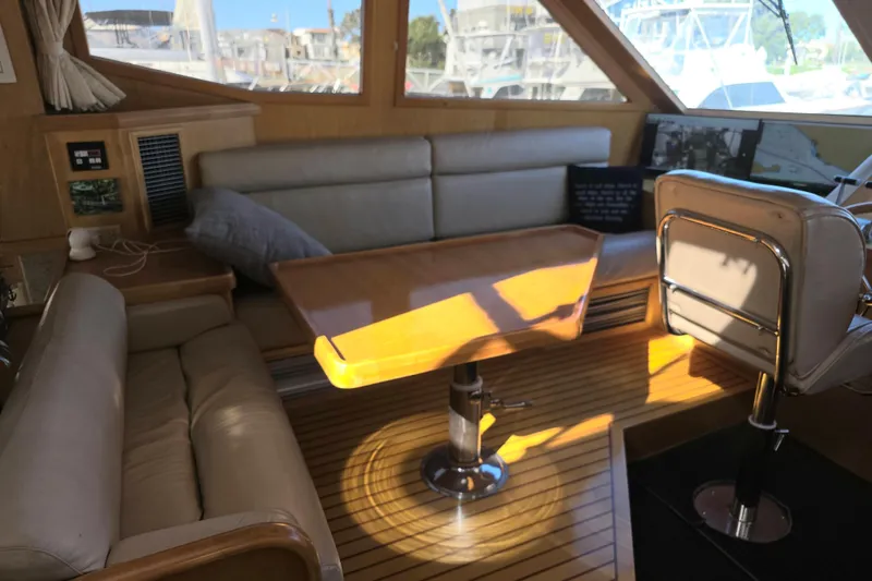 Interior of 2000 McKinna 48 Pilothouse with leather seating and wooden table.