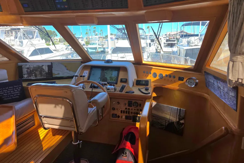 Pilothouse interior of 2000 McKinna 48, featuring navigation equipment and marina view.