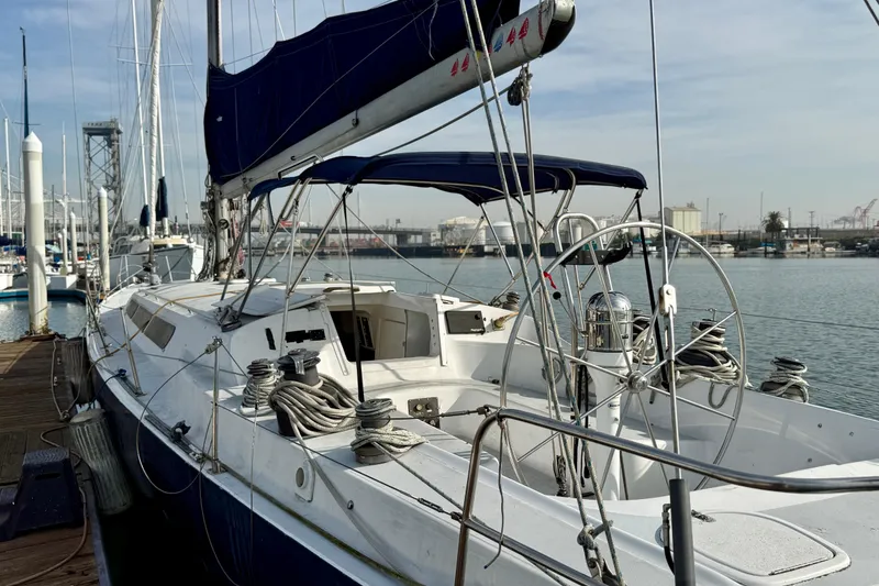 1985 MacGregor 65 sailboat docked at marina, featuring sleek design and spacious deck.