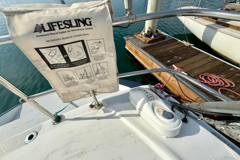Sailboat deck with Lifesling rescue system, MacGregor 65, 1985 model, docked at marina.