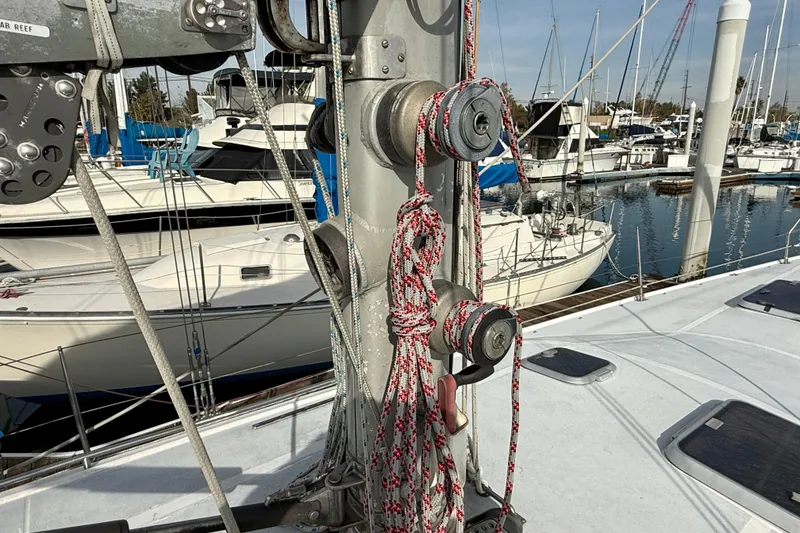 1985 MacGregor 65 sailboat mast with ropes in a marina setting.