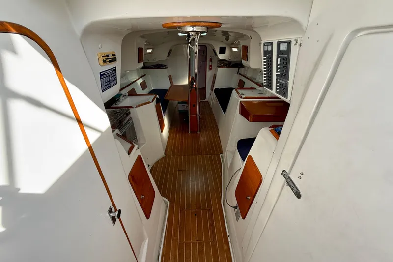 Interior of a 1985 MacGregor 65 sailboat, featuring wood accents and control panels.