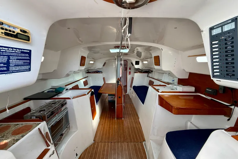 Interior of a 1985 MacGregor 65 sailboat, featuring a spacious cabin with wood accents.