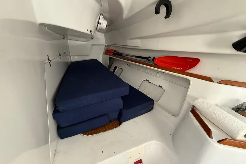 Interior of 1985 MacGregor 65 sailboat with blue cushions and red paddle.