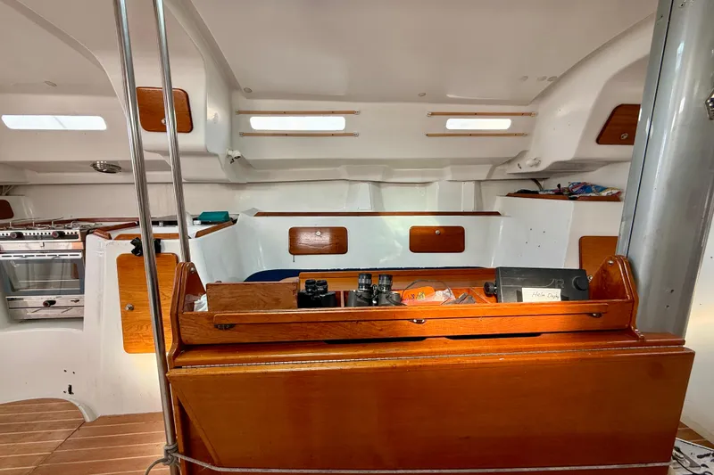 Interior of 1985 MacGregor 65 sailboat with wooden cabinetry and nautical equipment.