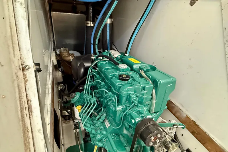 Engine compartment of a 1985 MacGregor 65 sailboat, featuring a green marine engine.