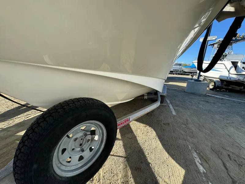 2016 Boston Whaler 170 MONTUCK boat on trailer, close-up view of hull and wheel.