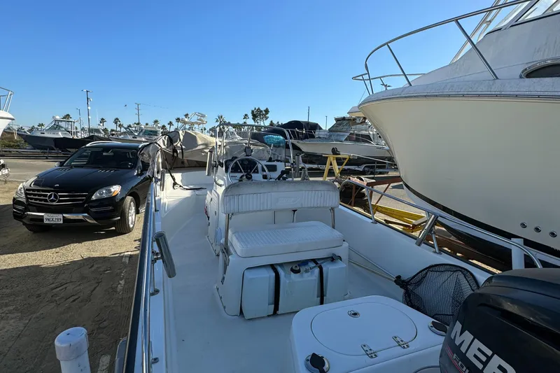 2016 Boston Whaler 170 MONTUCK boat docked near parked vehicles in a marina.