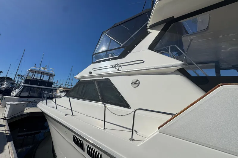 1990 Sea Ray 380 Aft Cabin yacht docked at marina under clear blue sky.