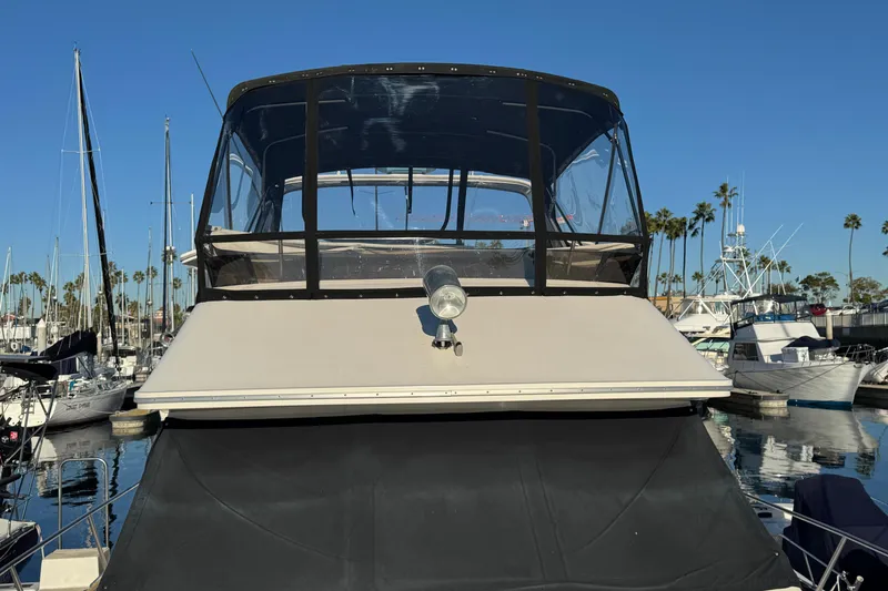1990 Sea Ray 380 Aft Cabin yacht docked in marina, clear blue sky.