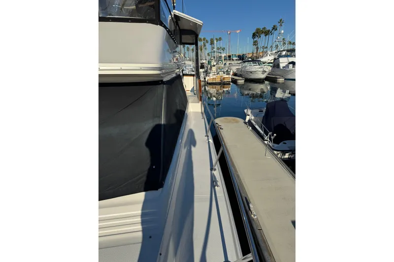 1990 Sea Ray 380 Aft Cabin yacht docked in a marina, surrounded by other boats.