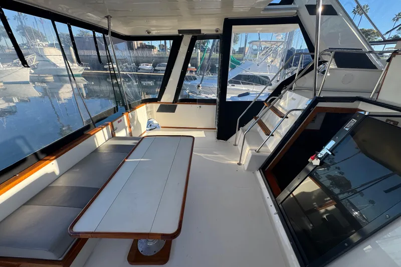 1990 Sea Ray 380 Aft Cabin interior with seating and table, docked at marina.