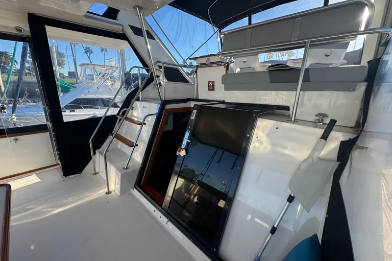 1990 Sea Ray 380 Aft Cabin interior with seating and stairs, docked at marina.