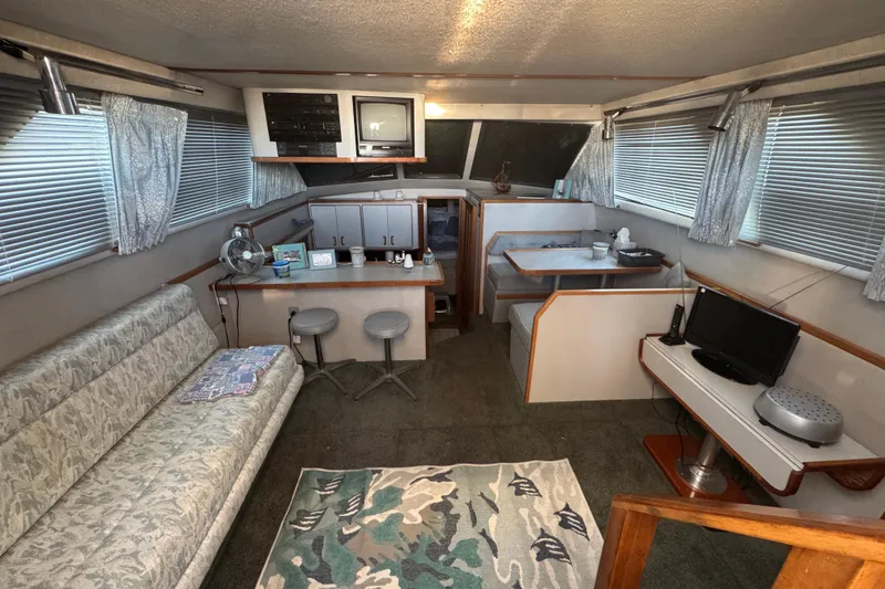 Interior of a 1990 Sea Ray 380 Aft Cabin with seating, TV, and dining area.